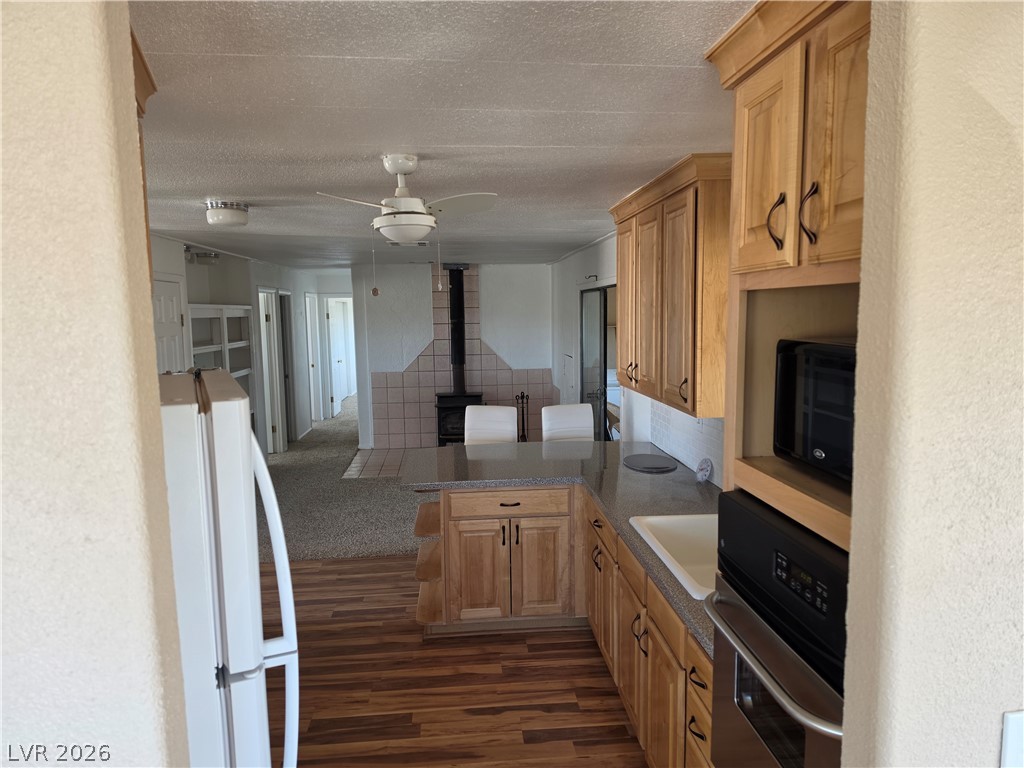 2930 Frehner Ranch Road Pioche, NV 89043 - Photo 37 of 39 A well-appointed kitchen features ample cabinetry, stone countertops, and a wood-burning stove in the adjacent living area.