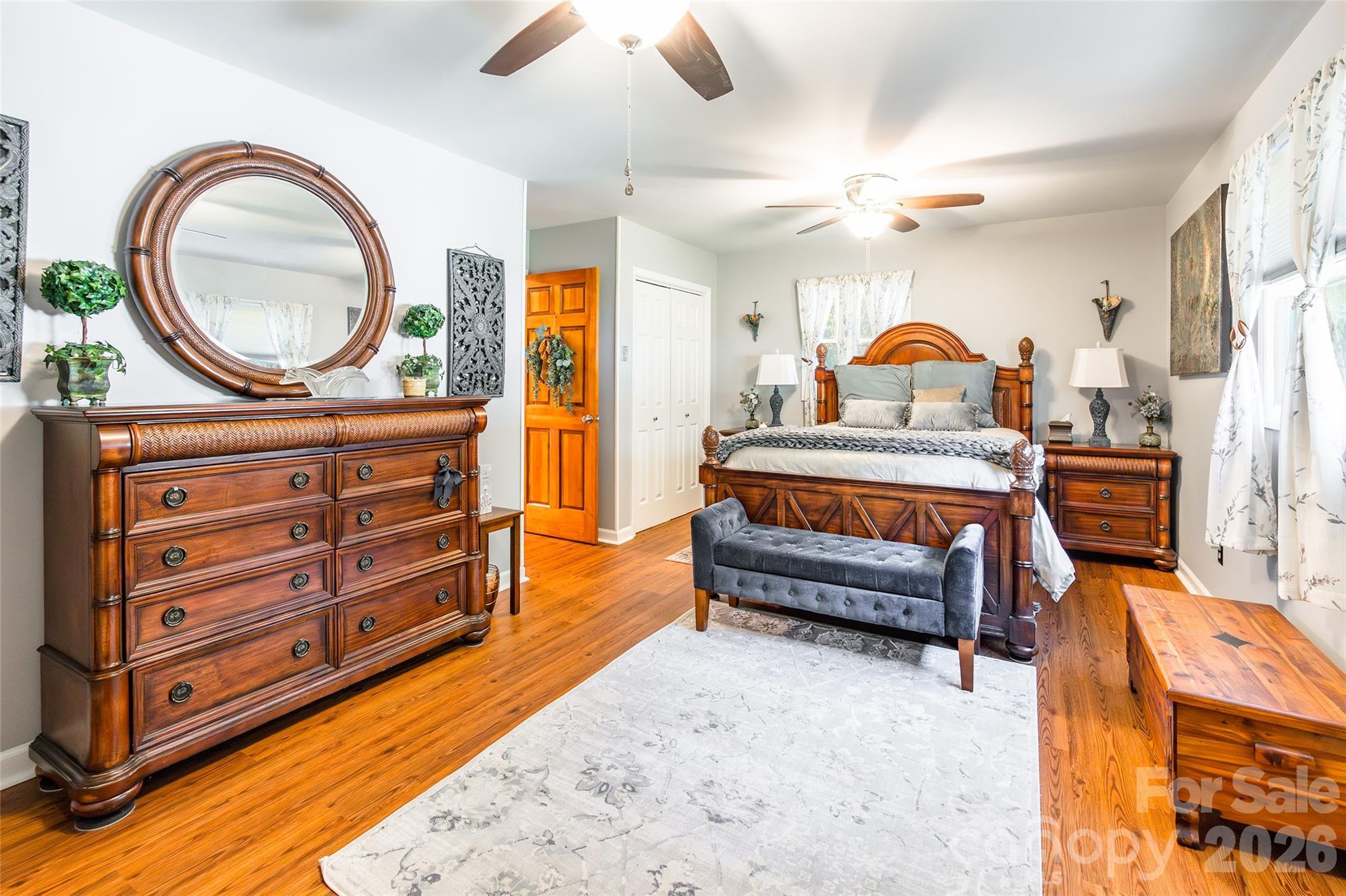 4205 Lake Shore Road South Denver, NC 28037 - Photo 18 of 46 a bedroom with a bed a mirror on dresser and a chandelier