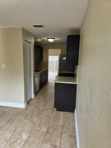 a view of a kitchen with cabinets and wooden floor
