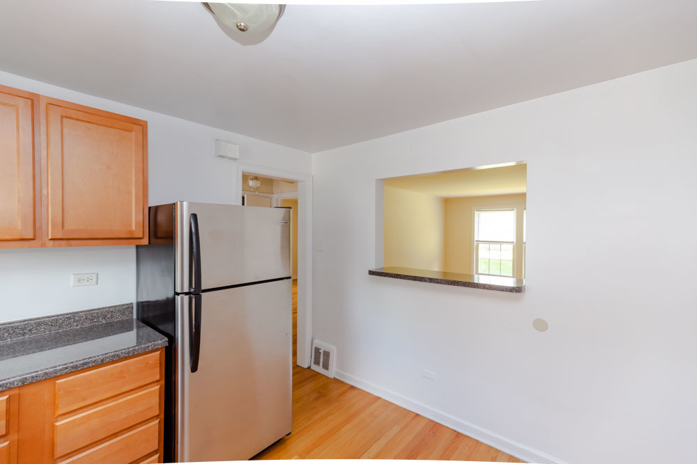 4245 West Nelson Street, Unit 1 Chicago, IL 60641 - Photo 5 of 8 a white refrigerator freezer and a stove sitting inside of a kitchen