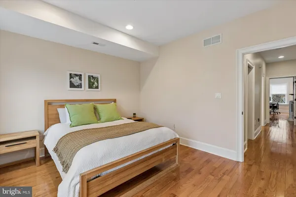 a bedroom with a bed and wooden floor