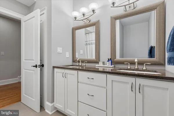 a bathroom with double sink and a mirror