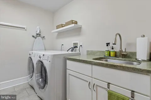 a utility room with sink dryer and washer
