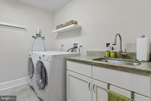 a utility room with sink dryer and washer