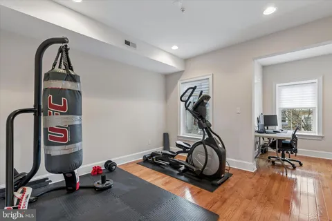 a room with gym equipment and wooden floor