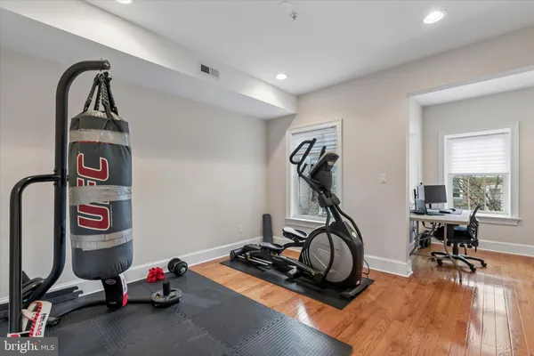 a room with gym equipment and wooden floor