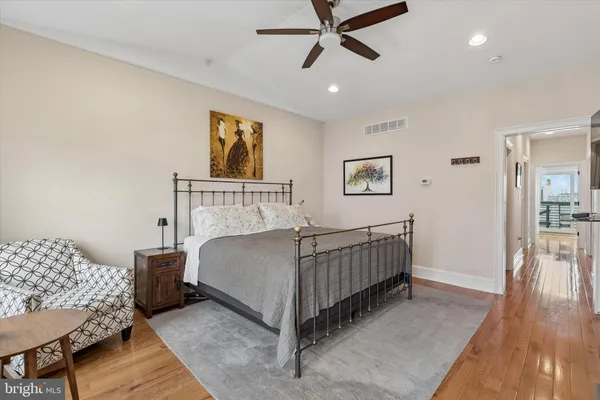 a bedroom with a bed and wooden floor