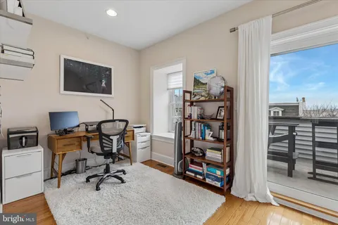 a view of a workspace with furniture and a window