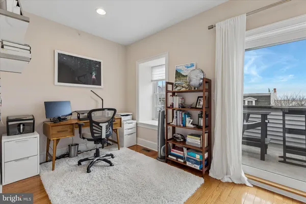 a view of a workspace with furniture and a window