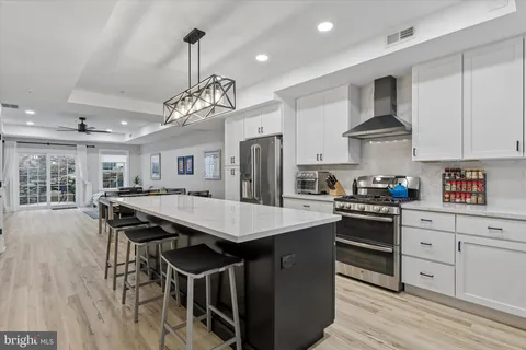 a kitchen with stainless steel appliances granite countertop a kitchen island a stove a table and chairs in it