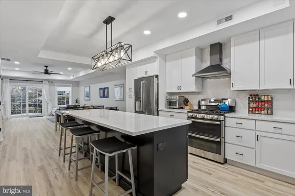 a kitchen with stainless steel appliances granite countertop a kitchen island a stove a table and chairs in it