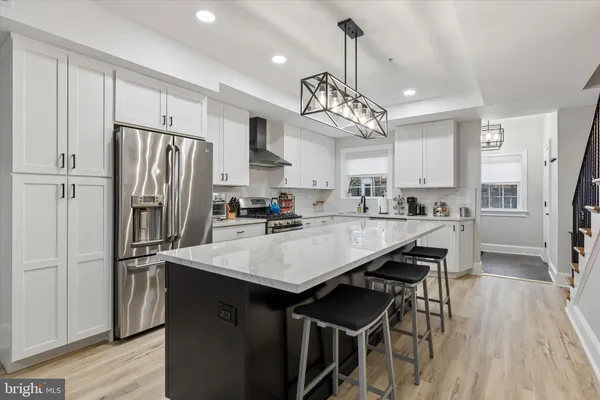 a kitchen with stainless steel appliances a table chairs refrigerator and microwave