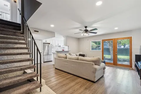 a living room with furniture and hard wood flooring