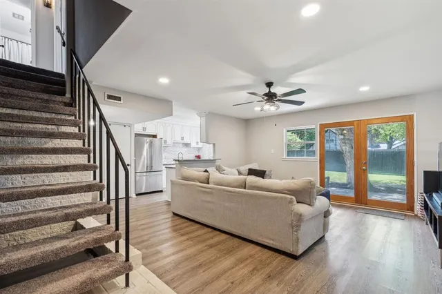 a living room with furniture and hard wood flooring