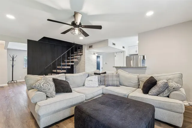 a living room with furniture and a ceiling fan