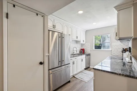 a kitchen with white cabinets and white appliances
