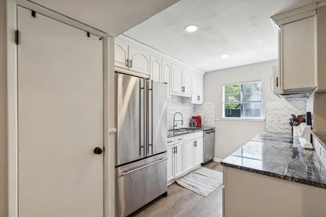 a kitchen with white cabinets and white appliances