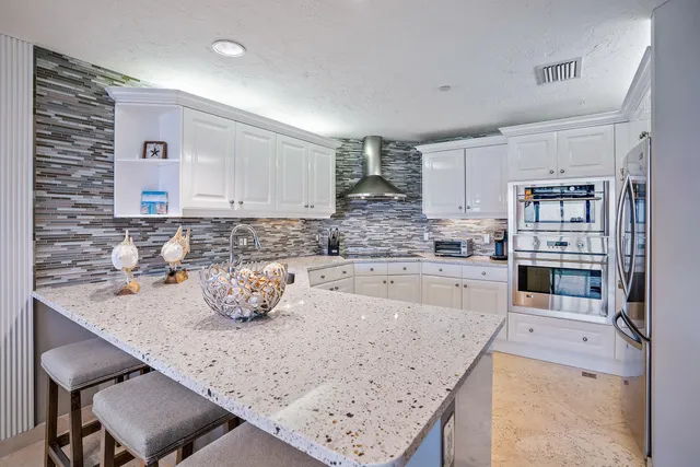 a kitchen with granite countertop a sink a stove and cabinets