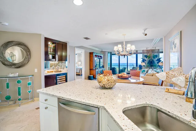a kitchen with a sink a stove and chairs