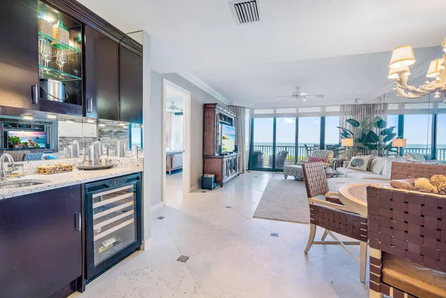 a living room with stainless steel appliances kitchen island granite countertop furniture and a large window