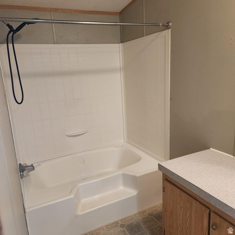 3760 Gold Ridge Drive, Unit 82 Magna, UT 84044 - Photo 23 of 29 White bathtub with integrated steps and a tile-patterned surround