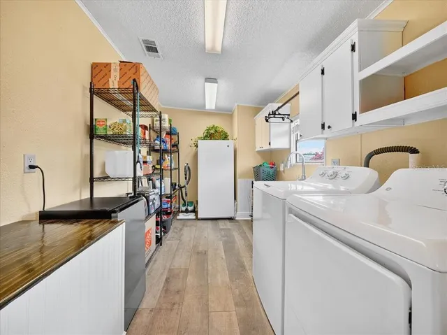 a view of a kitchen with fridge and wooden floor