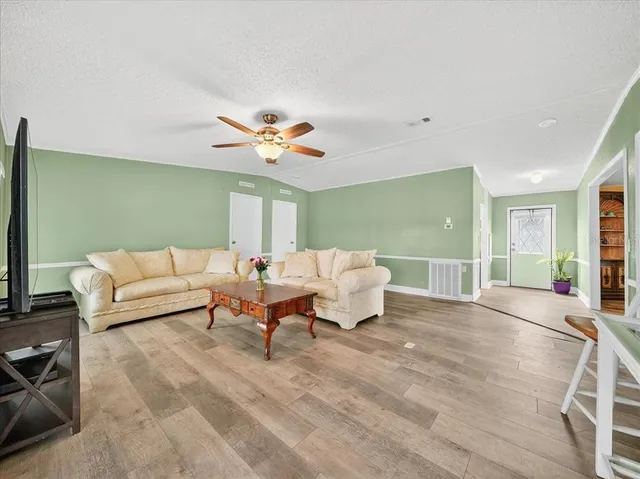 a living room with furniture and a ceiling fan