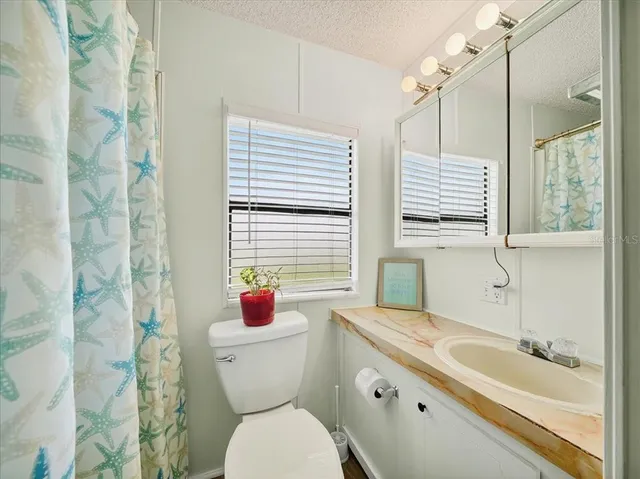 a bathroom with a granite countertop toilet a sink and a bathtub