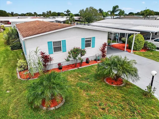 a view of a house with table and chairs under an umbrella