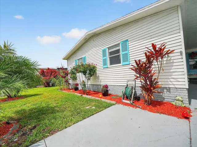 a front view of a house with a yard and potted plants