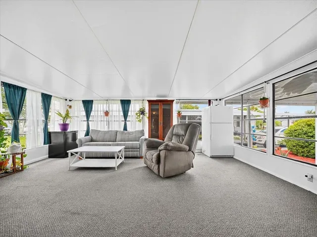 a living room with furniture and a floor to ceiling window