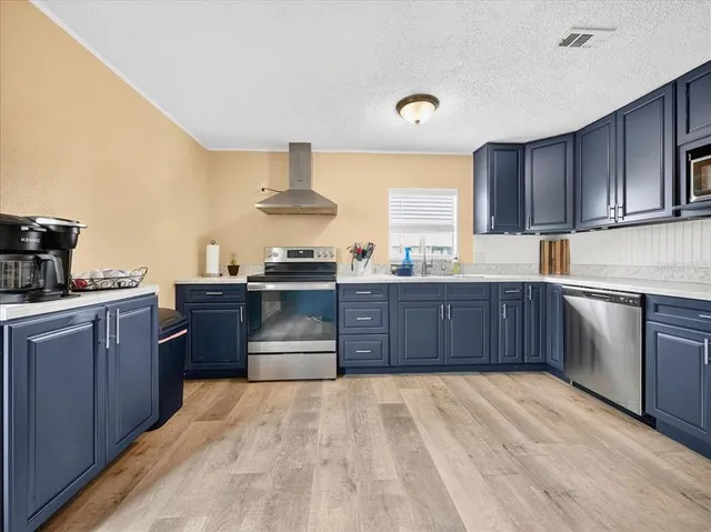 a kitchen with stainless steel appliances granite countertop a stove a sink dishwasher and a refrigerator