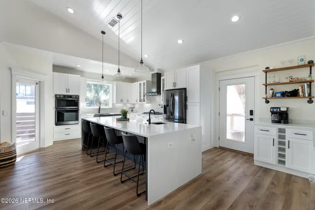 a bedroom with a large bed chandelier and a window