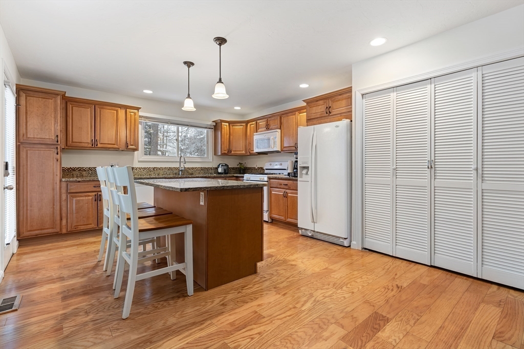 2 Arrowhead Circle, Unit 2 Ashland, MA 01721 - Photo 3 of 22 a kitchen with stainless steel appliances granite countertop a refrigerator a stove top oven a sink dishwasher and white cabinets with wooden floor