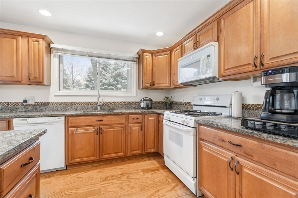 2 Arrowhead Circle, Unit 2 Ashland, MA 01721 - Photo 4 of 22 a kitchen with stainless steel appliances granite countertop a stove a sink and a white cabinets