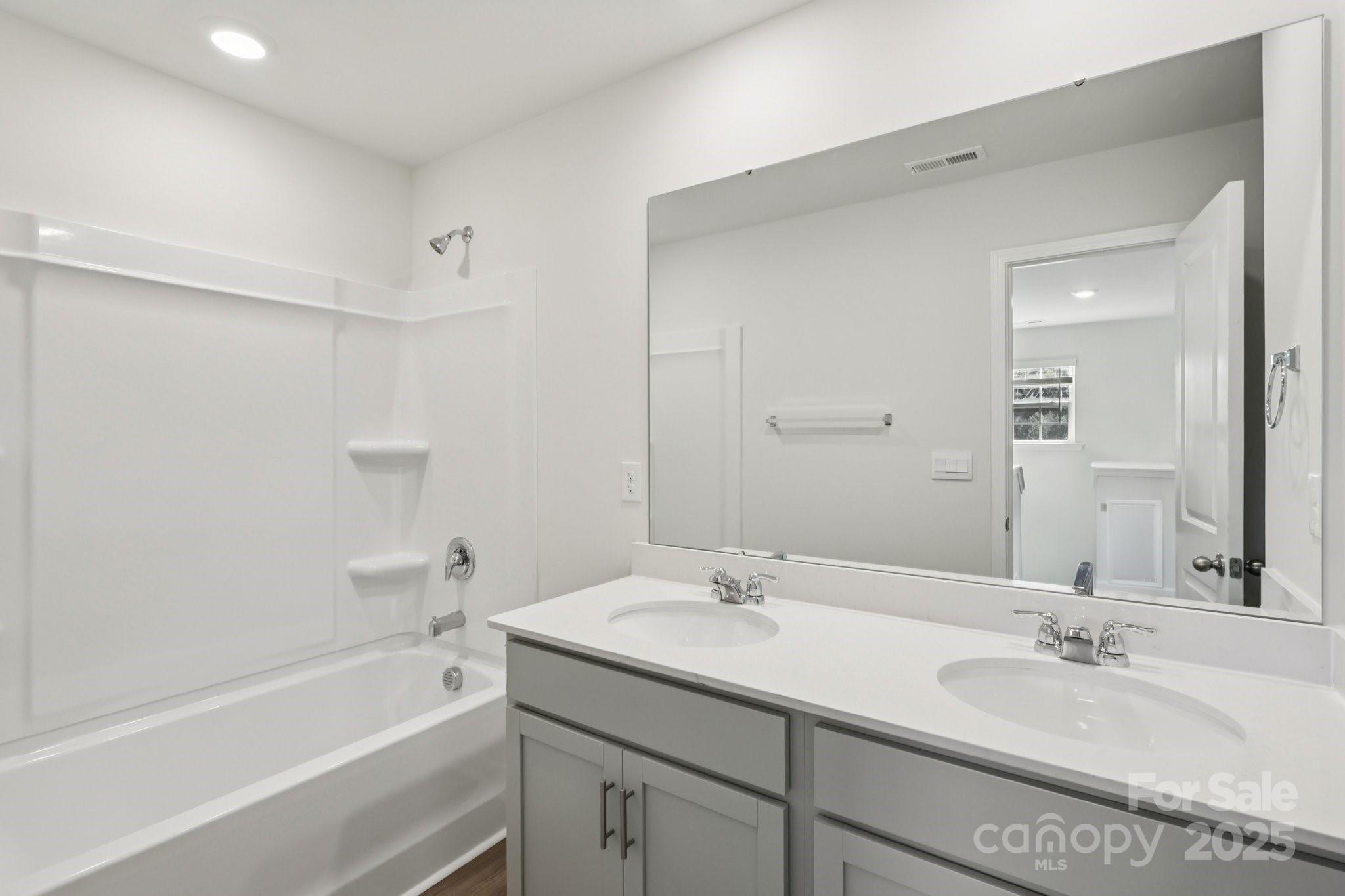 3919 Caroline Court Northwest Conover, NC 28613 - Photo 25 of 35 a bathroom with a sink double vanity granite tub shower and a mirror