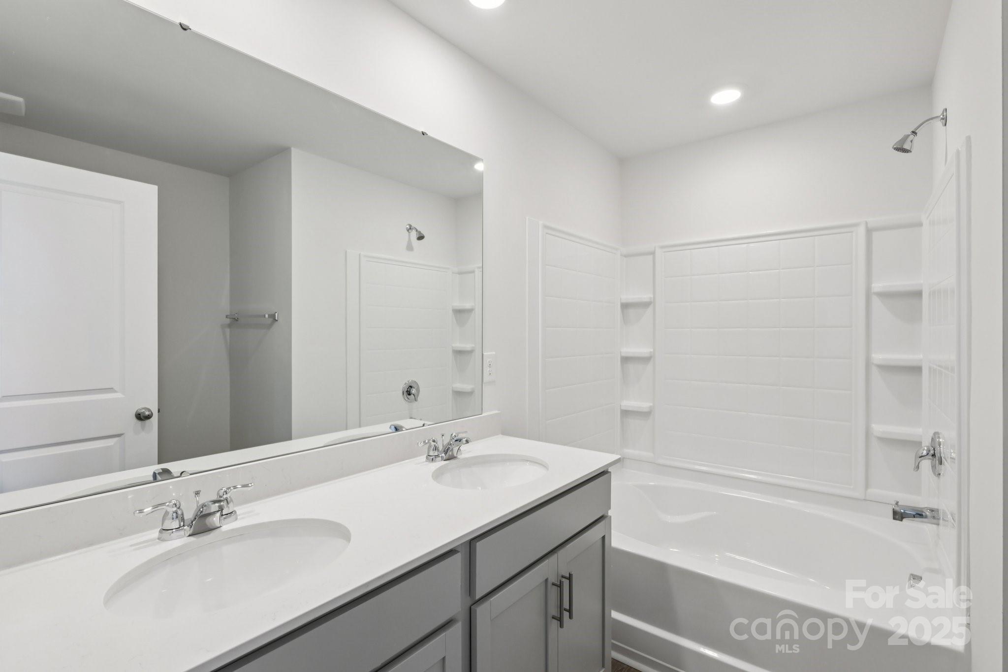 3919 Caroline Court Northwest Conover, NC 28613 - Photo 29 of 35 a bathroom with a bathtub shower sink vanity and a mirror