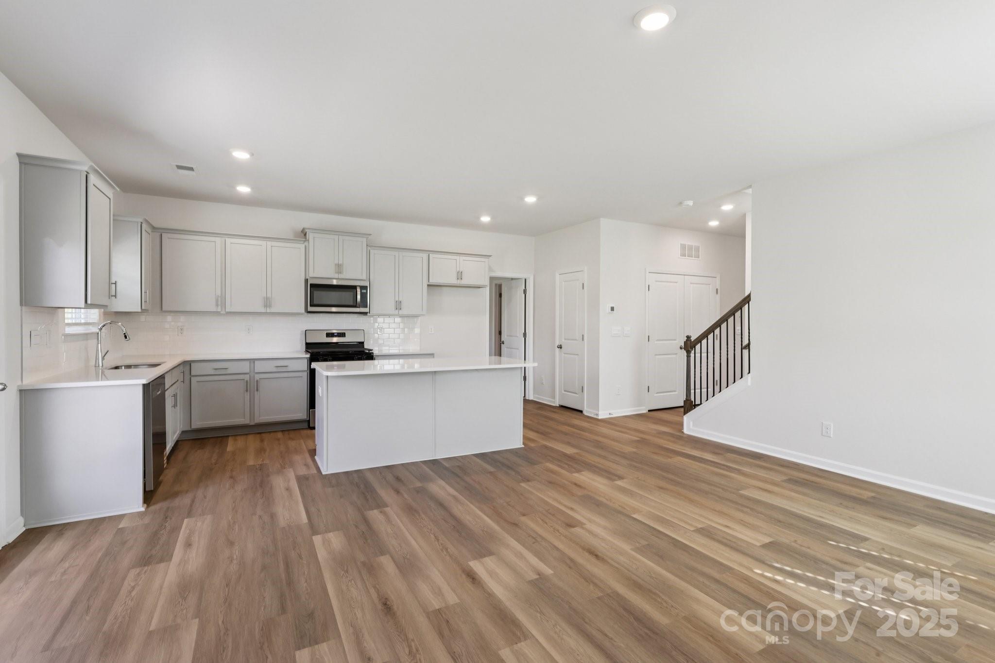 3919 Caroline Court Northwest Conover, NC 28613 - Photo 6 of 35 a large kitchen with kitchen island a sink a center island stainless steel appliances and a cabinets