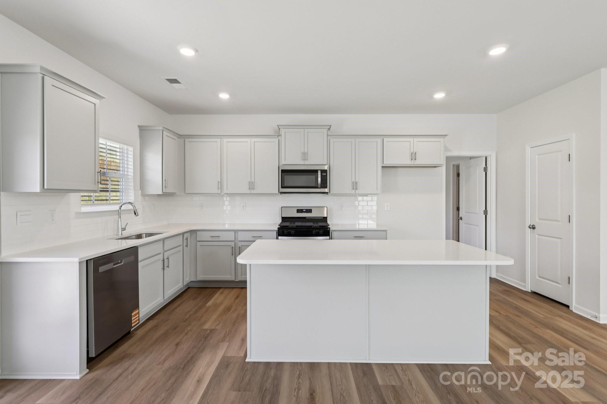 3919 Caroline Court Northwest Conover, NC 28613 - Photo 9 of 35 a kitchen with stainless steel appliances a refrigerator sink and white cabinets