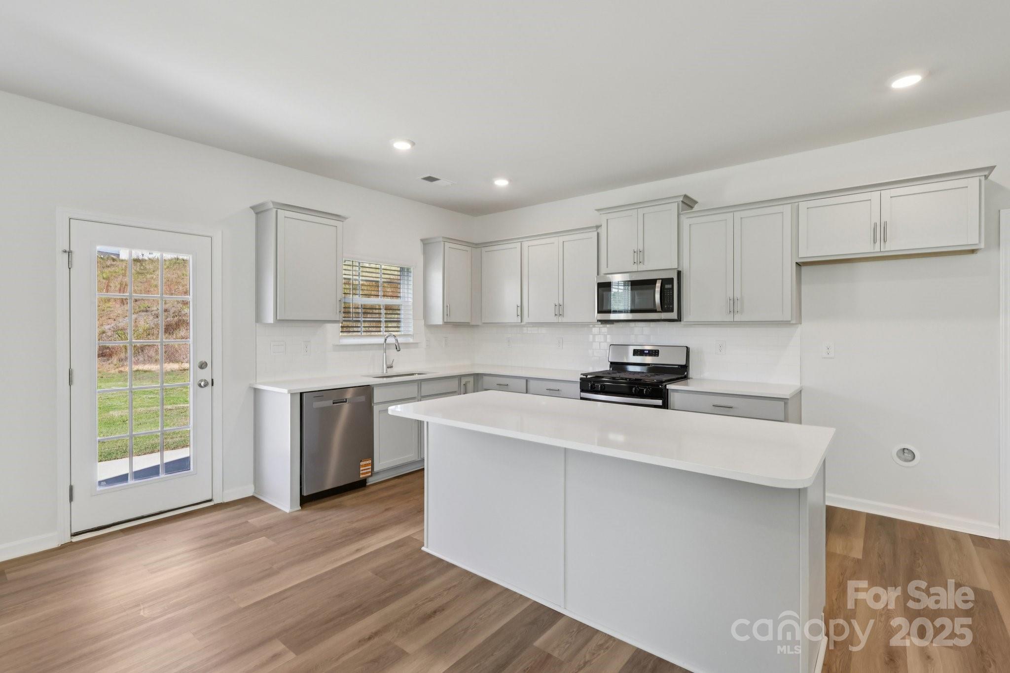 3919 Caroline Court Northwest Conover, NC 28613 - Photo 10 of 35 a kitchen with a sink a stove a refrigerator cabinets and a window