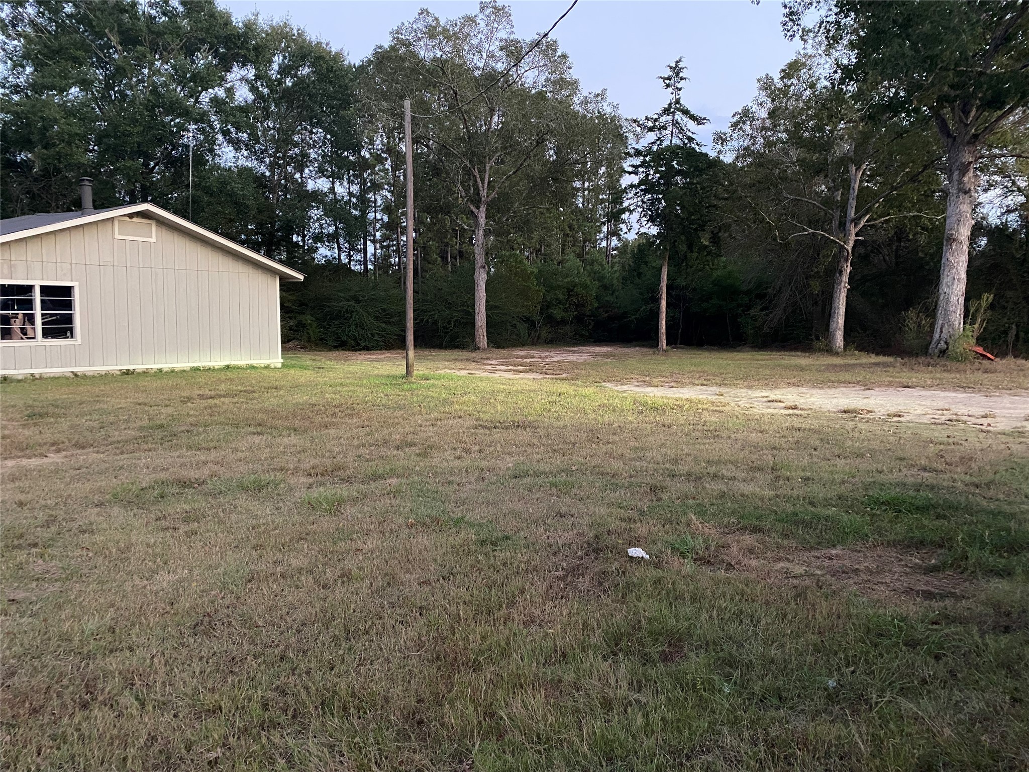 983 County Road, Unit 4350 Woodville, TX 75979 - Photo 6 of 18 a backyard of a house with large trees