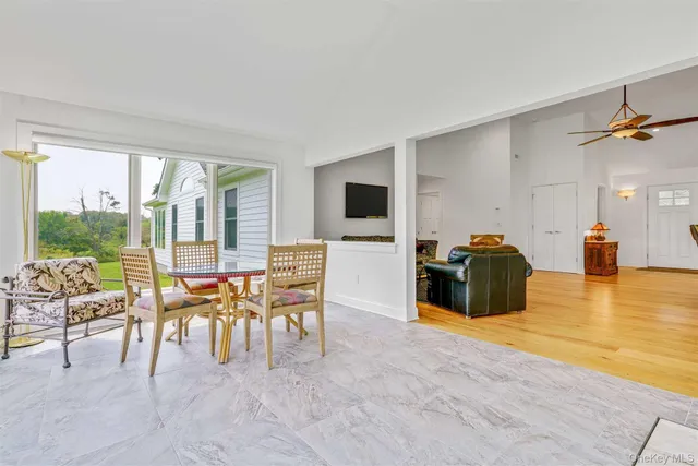 a dining room with furniture and a floor to ceiling window
