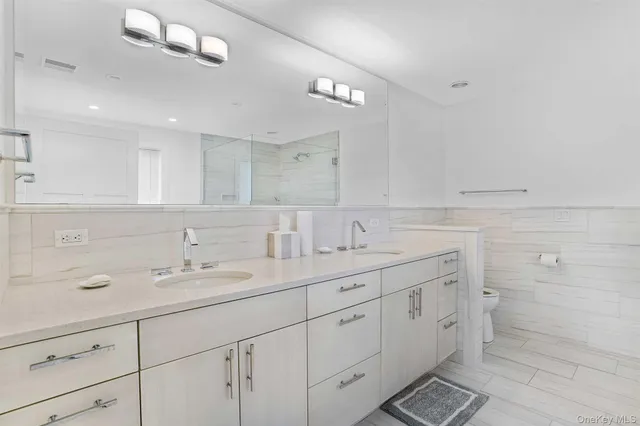 a spacious bathroom with double sink and a mirror