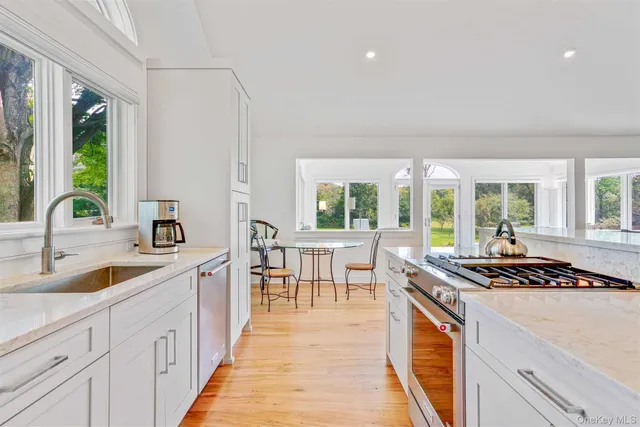a kitchen that has a sink and chairs