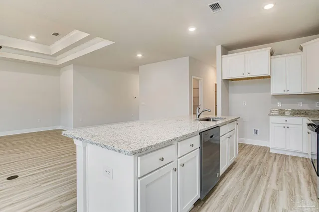 a kitchen with granite countertop white cabinets and white appliances