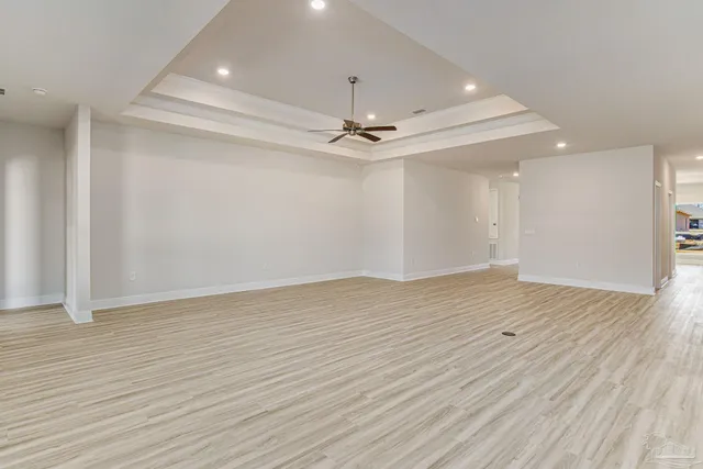 wooden floor in an empty room with a ceiling fan