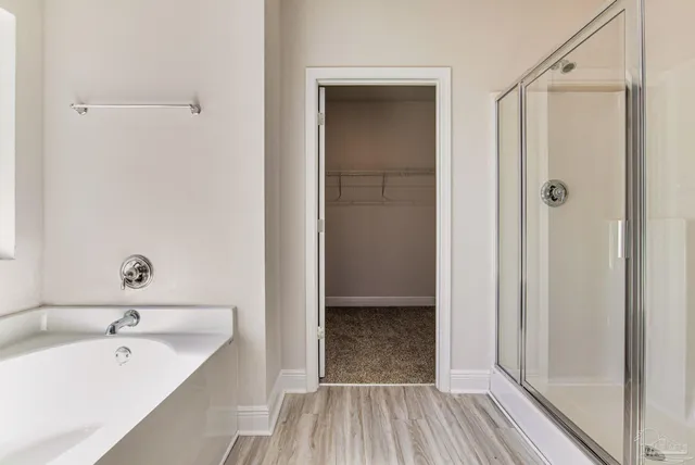 a bathroom with a tub shower vanity and a sink