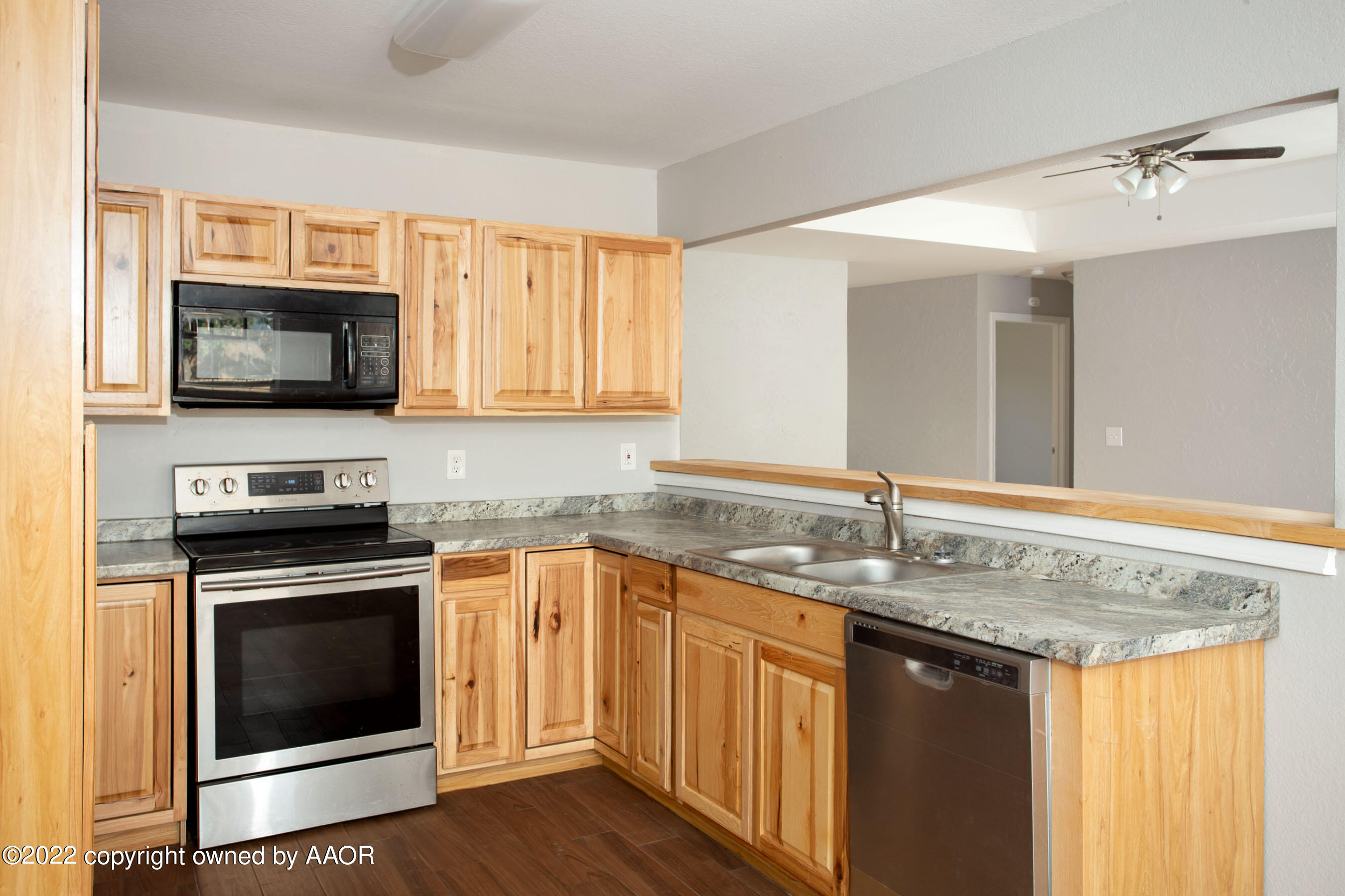 3808 Ross Street Amarillo, TX 79118 - Photo 12 of 22 a kitchen with stainless steel appliances granite countertop a sink stove and microwave