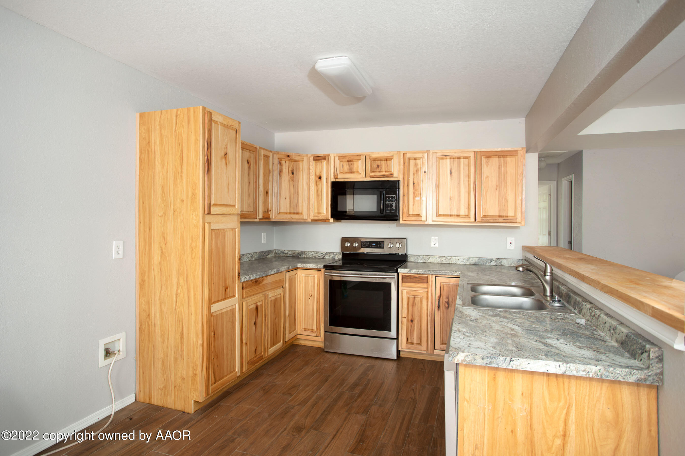 3808 Ross Street Amarillo, TX 79118 - Photo 3 of 22 a kitchen with granite countertop a stove a sink and a microwave