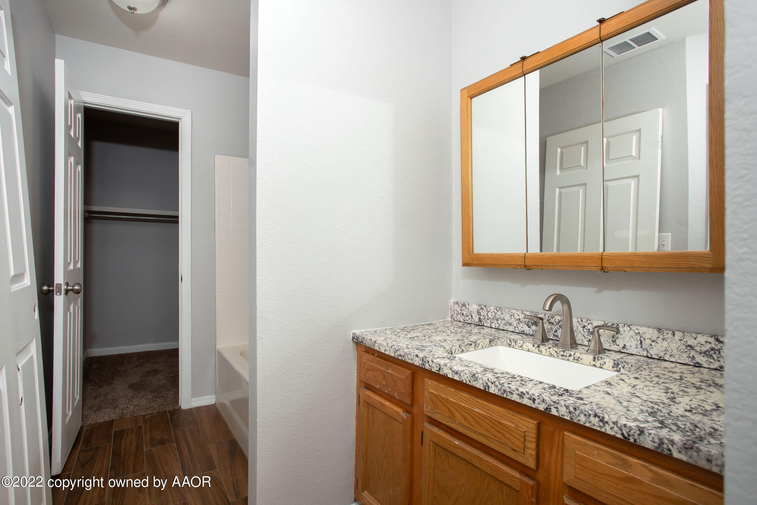 3808 Ross Street Amarillo, TX 79118 - Photo 5 of 22 a bathroom with a granite countertop sink and a mirror